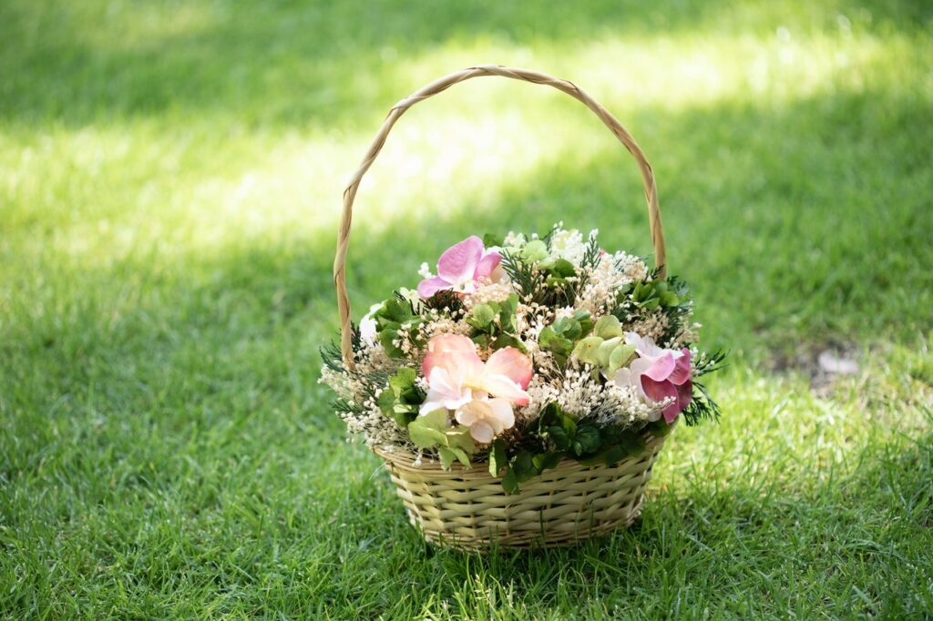 Májuskosár: rózsaszín és fehér virágok egy füleskosárban