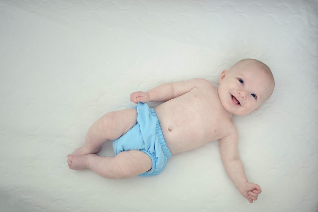 Kék mosható pelenka egy babán